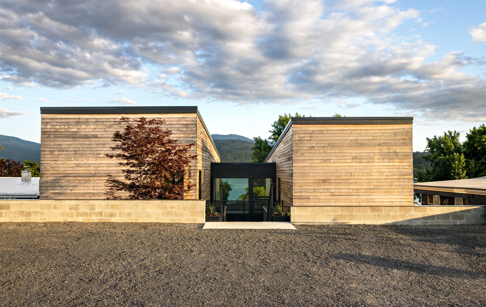 Twin cedar pavilions and the entry gate at golden hour