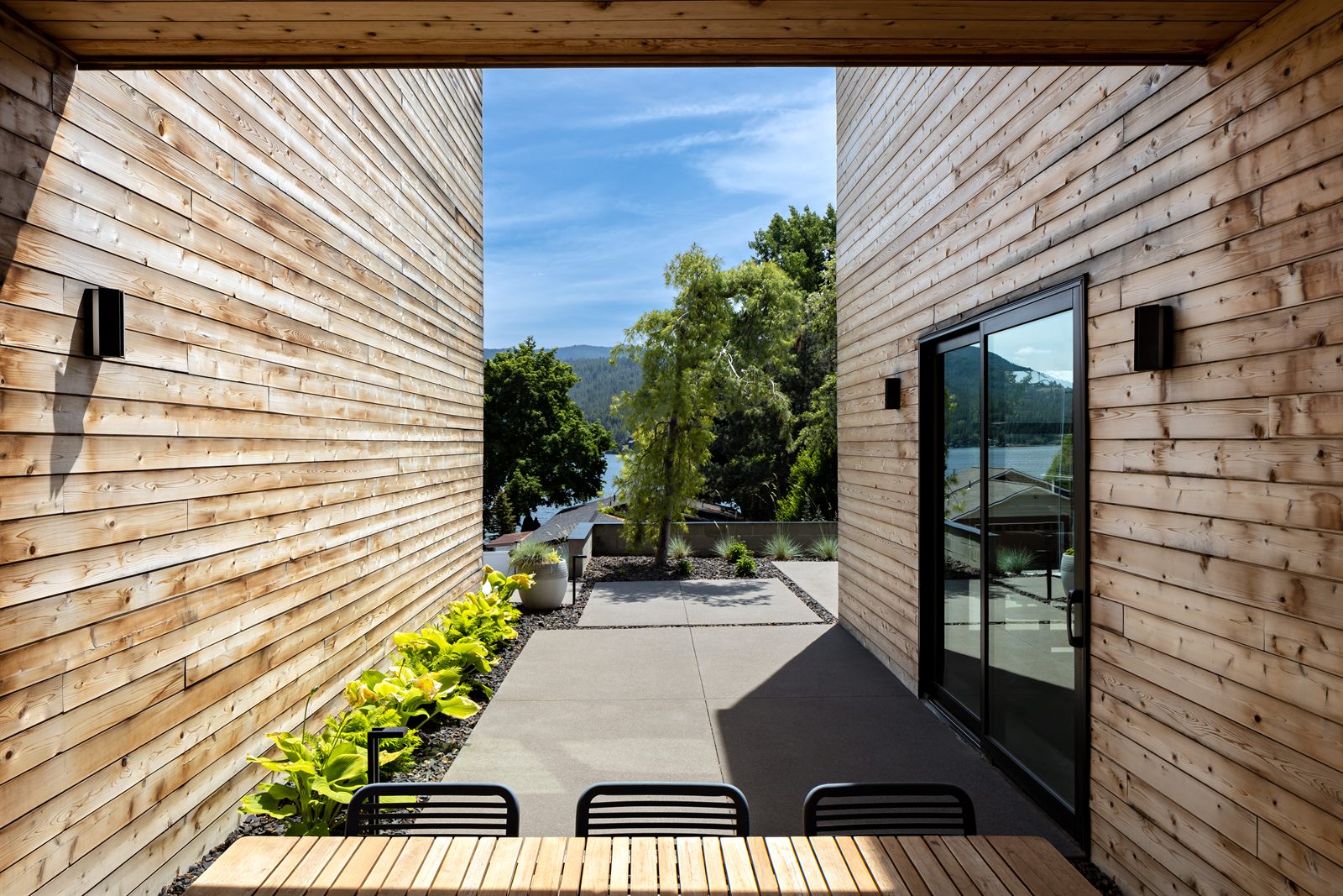Courtyard opening to a lake view between cedar walls