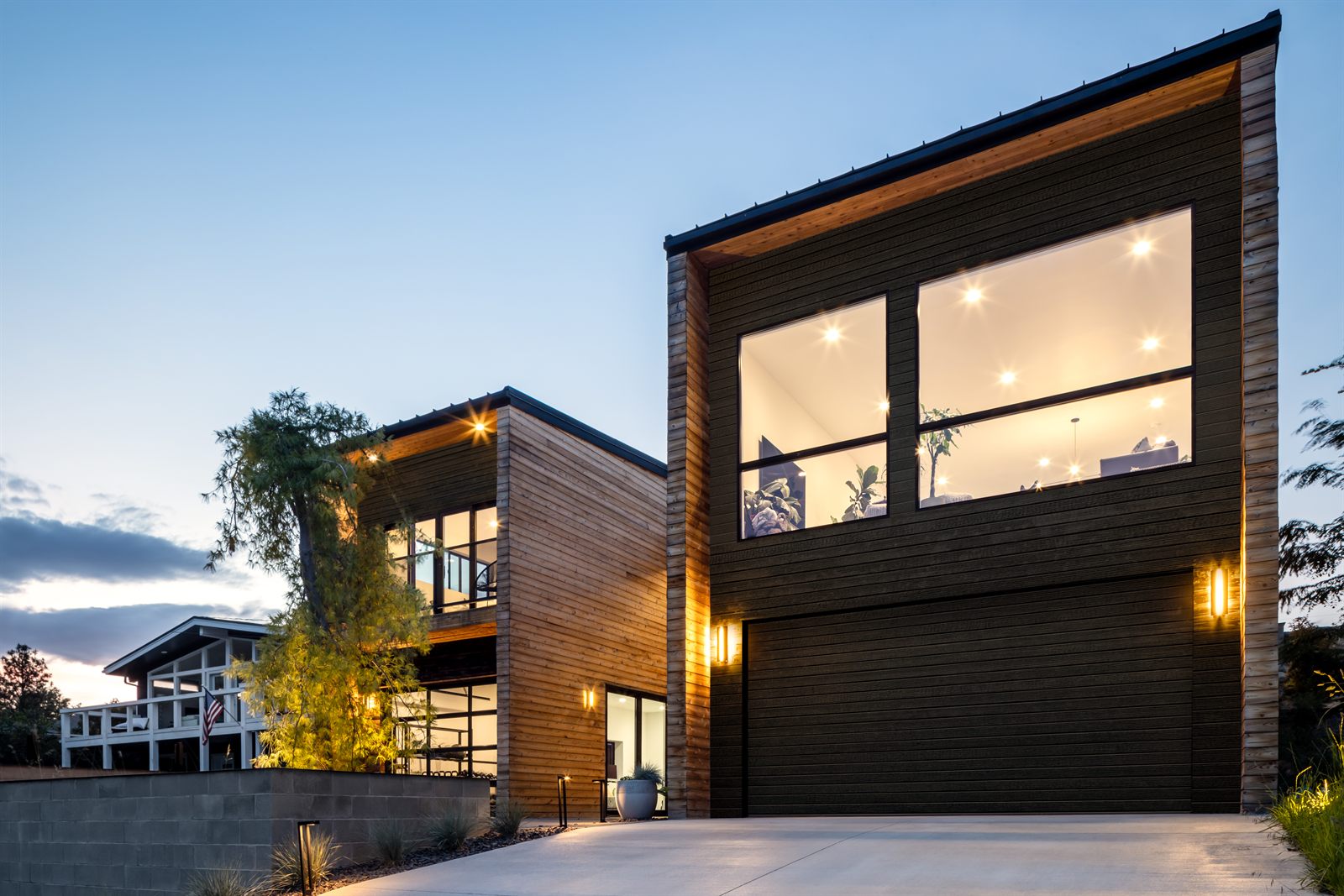 Modern home exterior glowing at twilight above the drive