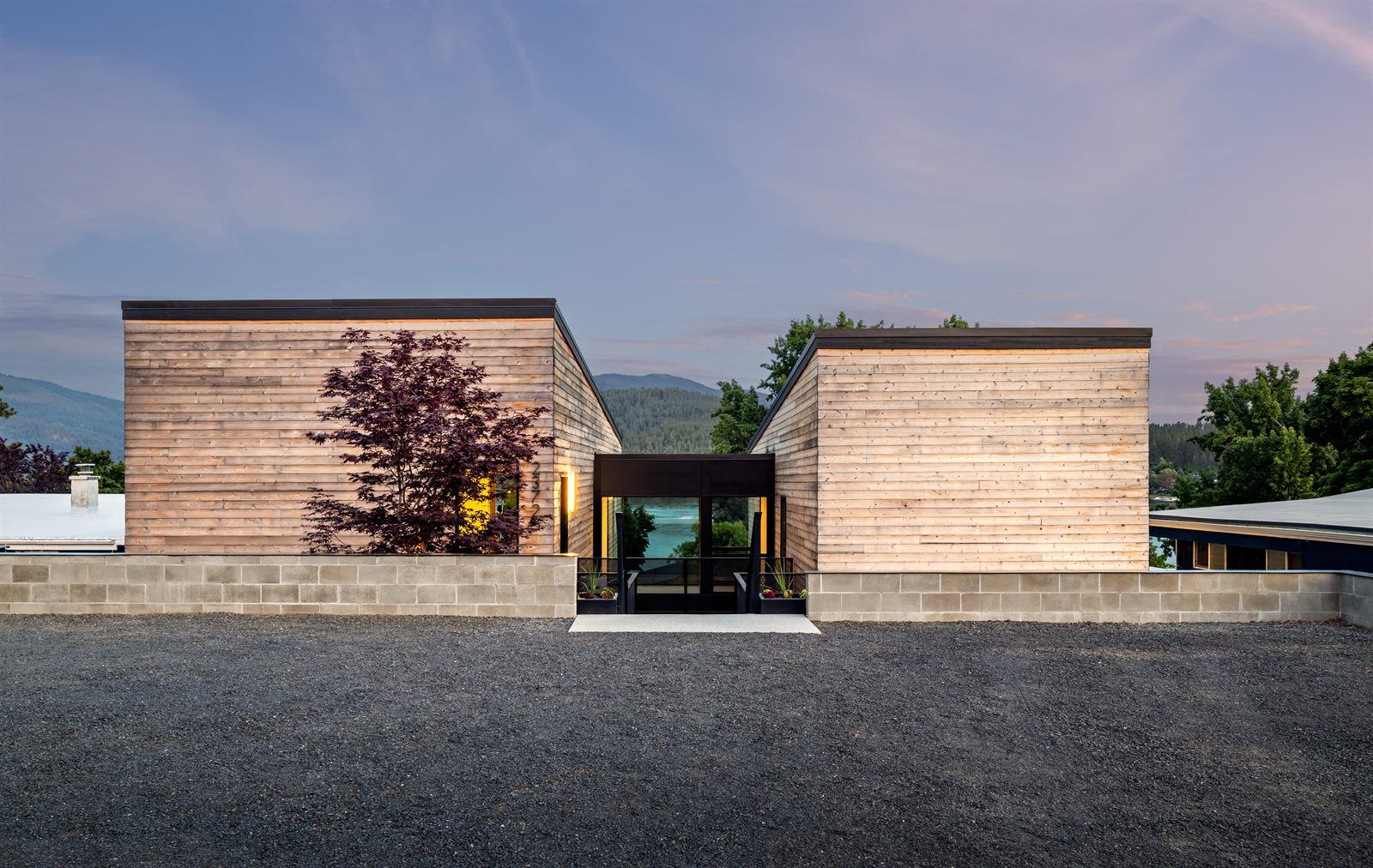 Front elevation at twilight behind the gravel forecourt