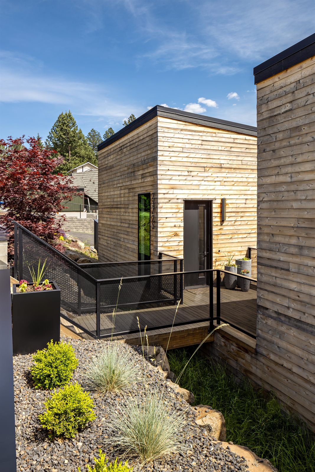 Entry deck and steel planters along the cedar facade