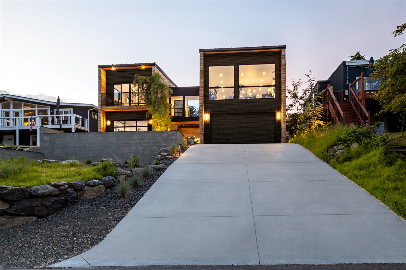 Concrete drive rising to the modern home at dusk